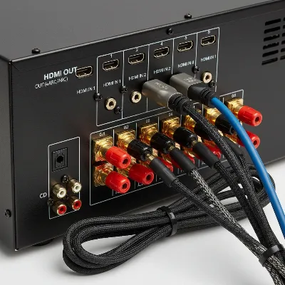 A close-up shot of the rear panel of an AV receiver with various color-coded ports and connected HDMI and speaker cables, emphasizing organized connections for a home theater setup, realistic style.